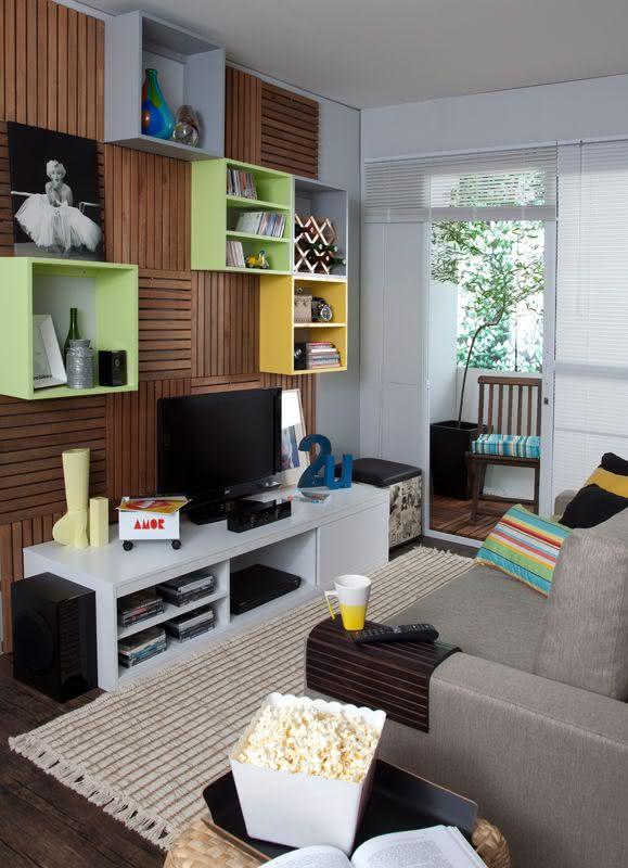 Imagem 37 – Sala de TV com painel de madeira e nichos coloridos na Sala De Tv Pequena Ideias ~ Imagem 37 – Sala de TV com painel de madeira e nichos coloridos na