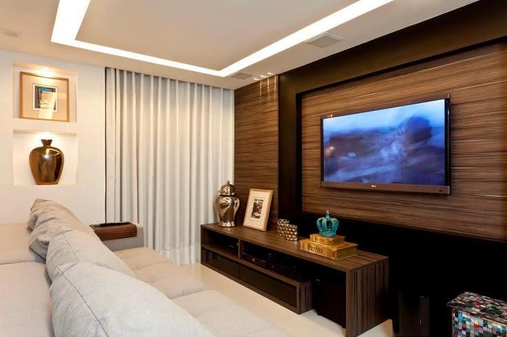 Imagem 53 – Sala de TV com bancada branca e painel de madeira Home Para Sala De Tv Pequena ~ Imagem 53 – Sala de TV com bancada branca e painel de madeira