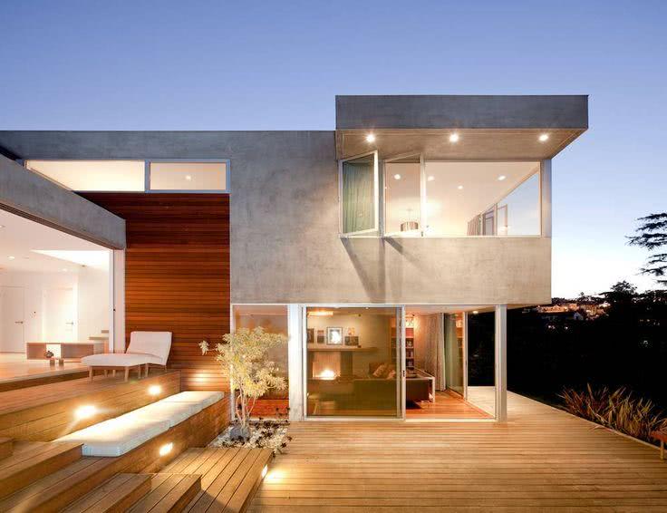 Fachada de casa moderna com revestimento em concreto e madeira.