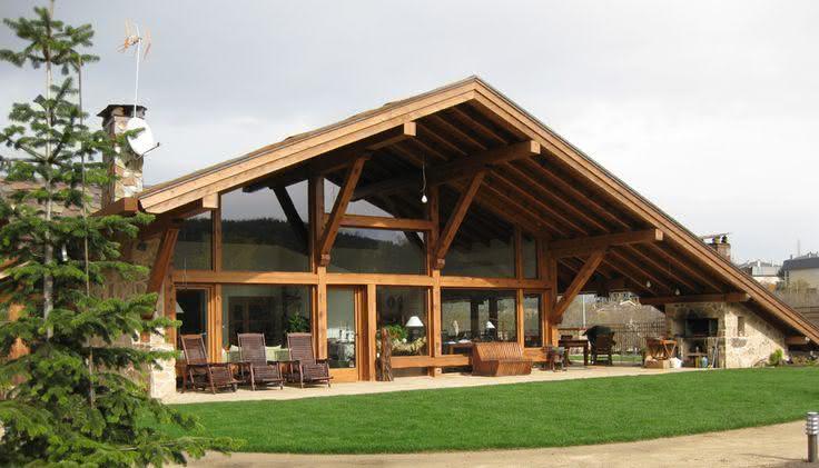 Fachada com estrutura em madeira e janelas amplas de vidro