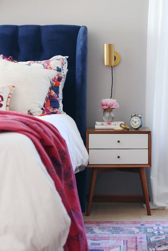 Cabeceira azul com roupa de cama rosa