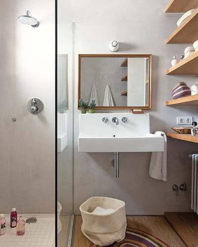 Banheiro pequeno com prateleiras de madeira.