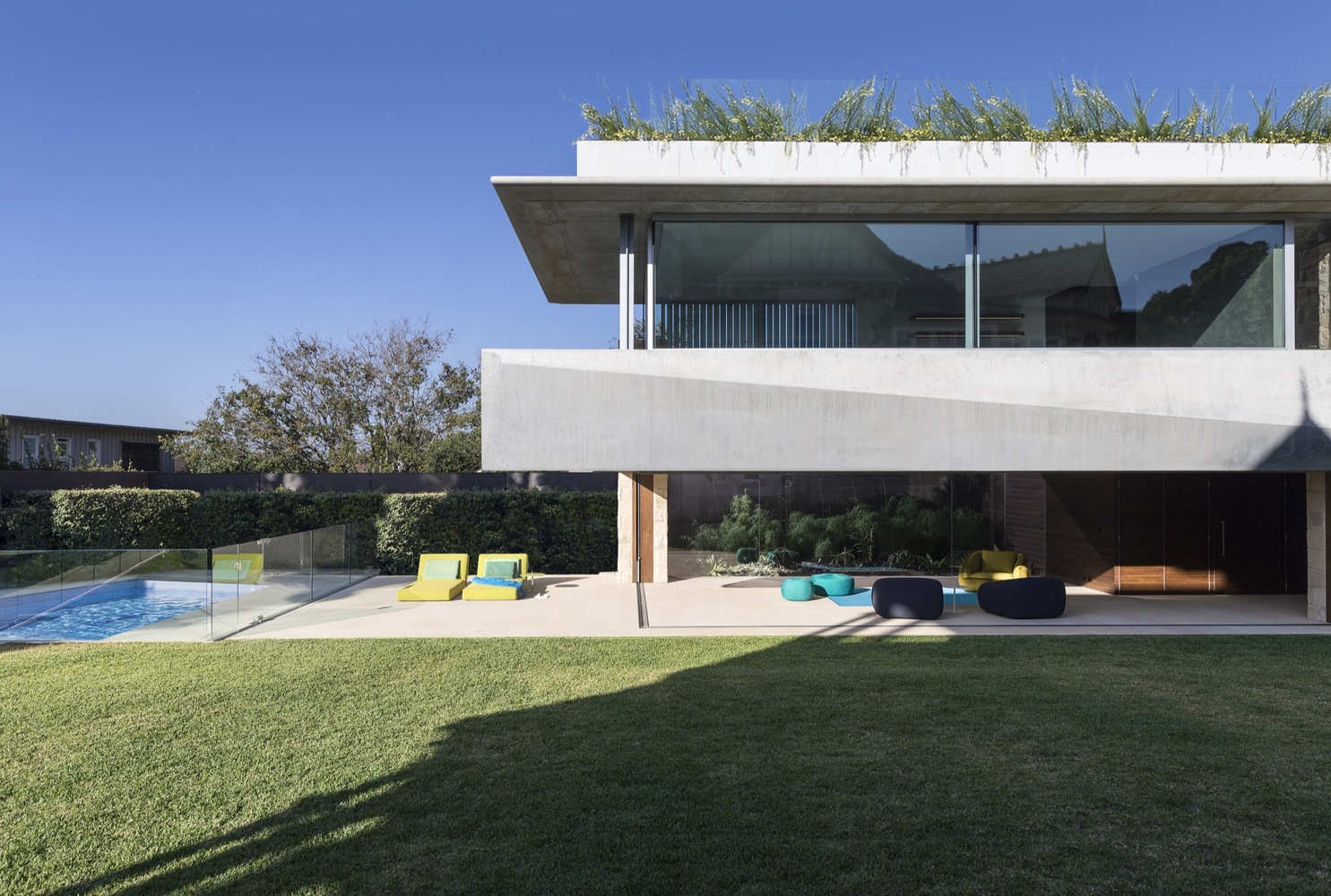 Luxury home outdoor area with pool, green area and glass railing