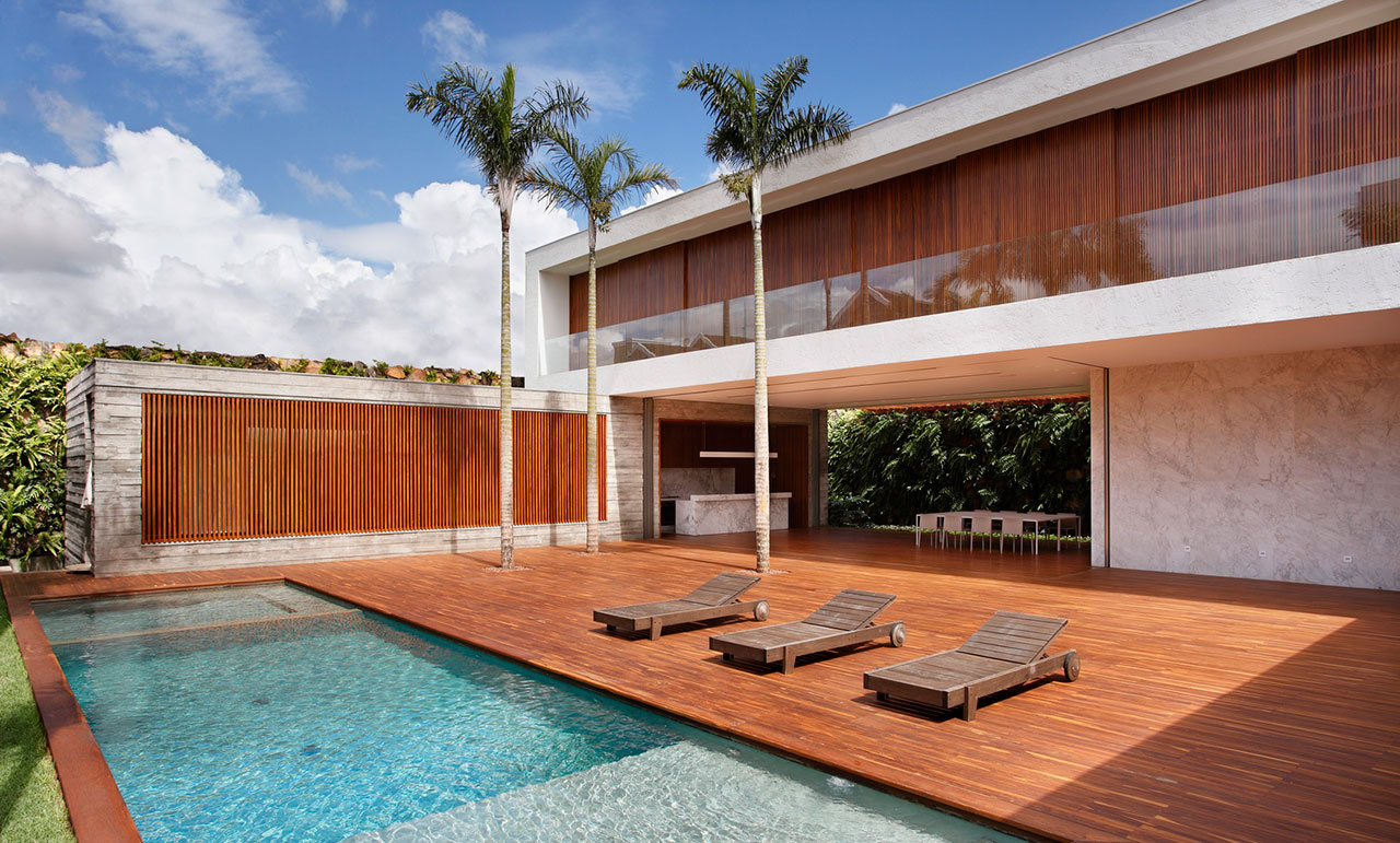 Back of a beautiful house with wood deck and glass railing on upper deck porch