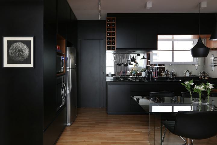 O fundo da bancada da cozinha foi revestido com espelho dando um visual mais clean a decoração preta!