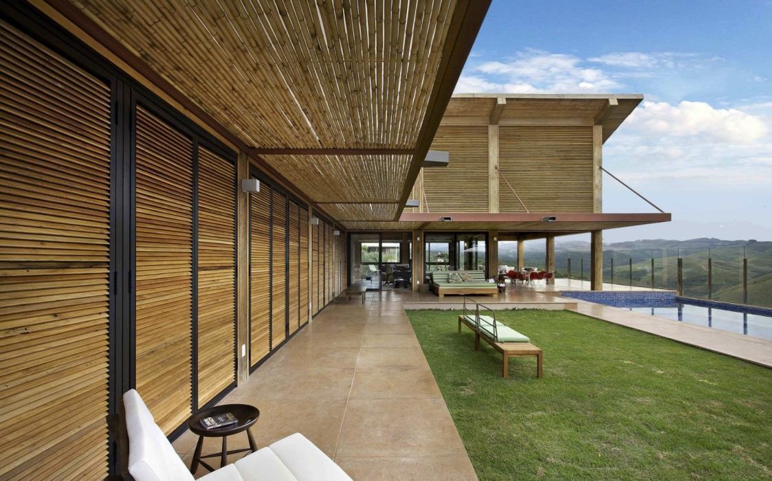 Mesmo presa por tirantes, a cobertura de bambu consegue complementar a linda fachada residencial
