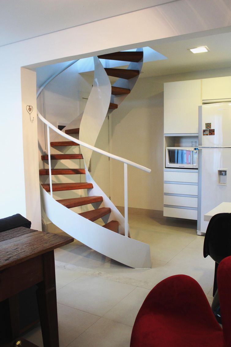 Escada caracol na cozinha com ambientes integrados para ligação com o segundo pavimento