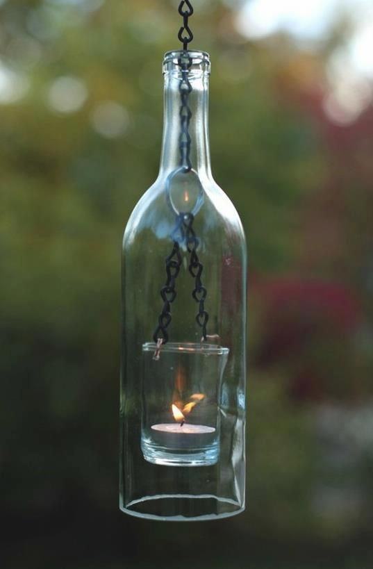 Luminária suspensa com garrafa de vidro e vela.
