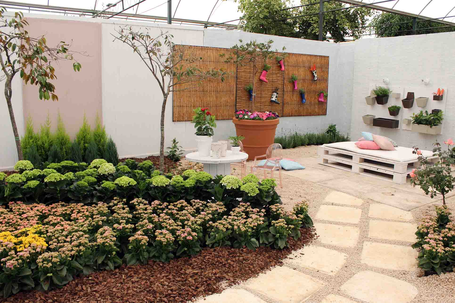 Jardim decorado com materiais recicláveis e pallets.