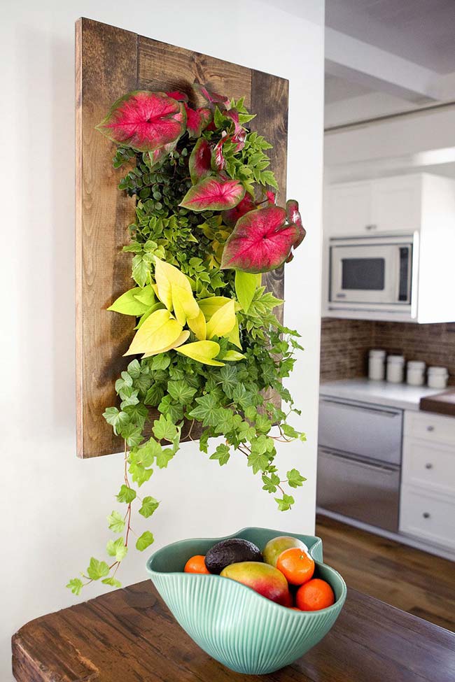 A vivid, natural painting of anthuriums and ivy decorates the space between the dining room and the kitchen.