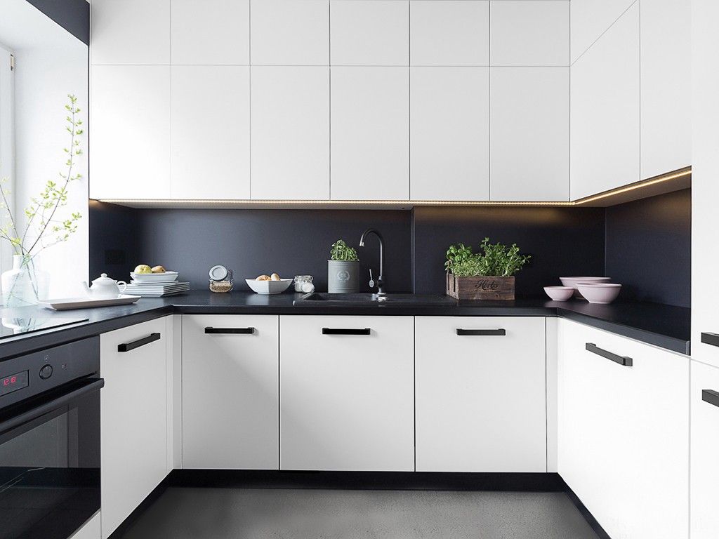Armário de cozinha branco com puxador preto e iluminação
