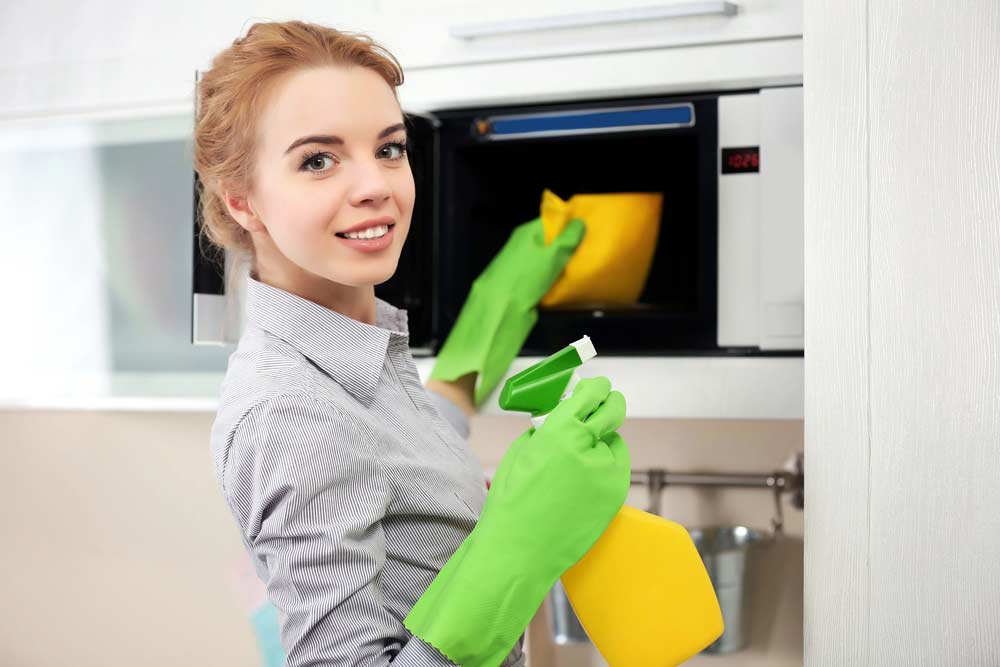 Mulher fazendo limpeza de micro-ondas