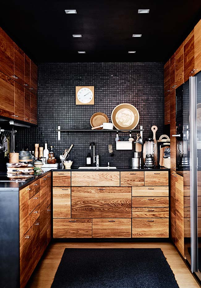 Iluminação em cozinha preta com madeira