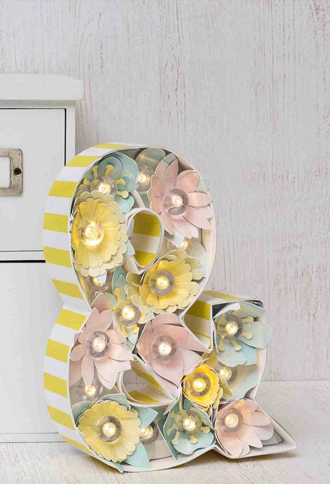 Letra decorativa feita com papel e flores artificiais