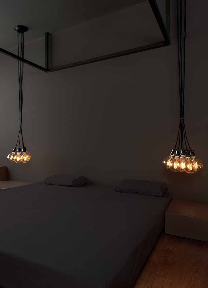 Um quarto minimalista todo preto com um ‘buquê’ de lâmpadas de carbono