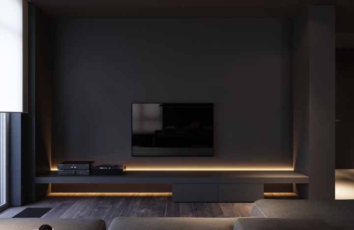 A parede preta da TV ganhou uma iluminação especial com fitas de LED 