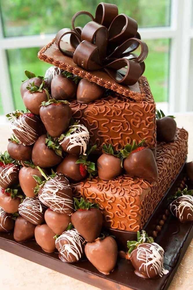 Bolo em formato de caixa transbordando bombons cobertos de chocolate