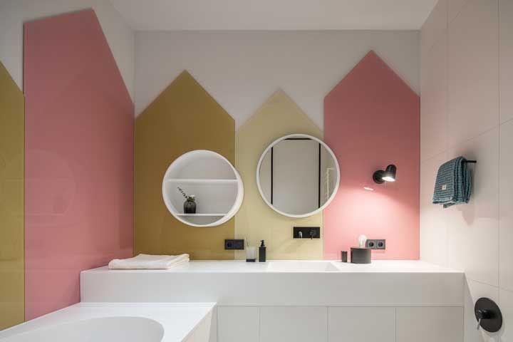 A parede colorida e geométrica apostou em nichos brancos para o espelho e para organizar os objetos