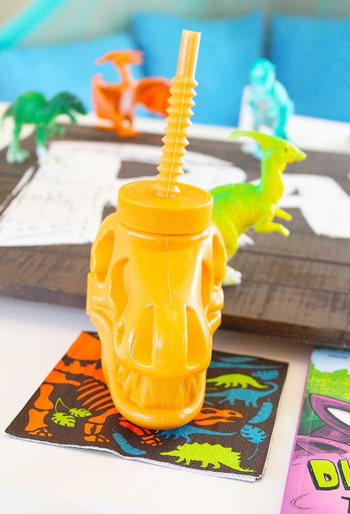 Que tal comprar garrafas personalizadas com o tema dinossauros? É uma ótima opção para servir as bebidas da festa.