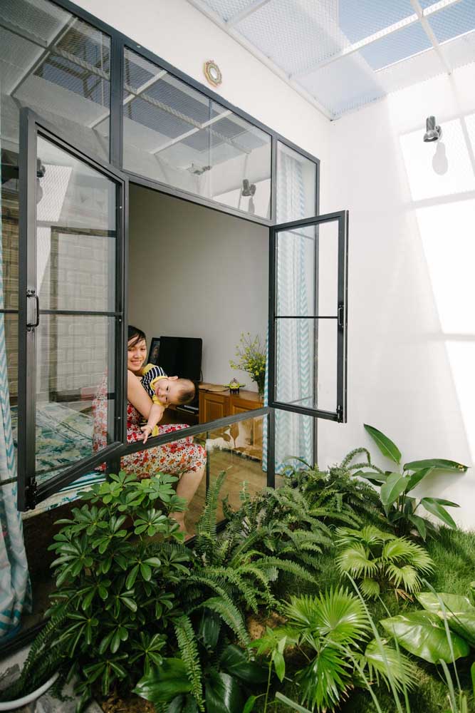 Teto translúcido para as plantas e janela de vidro para os moradores apreciarem o jardim 