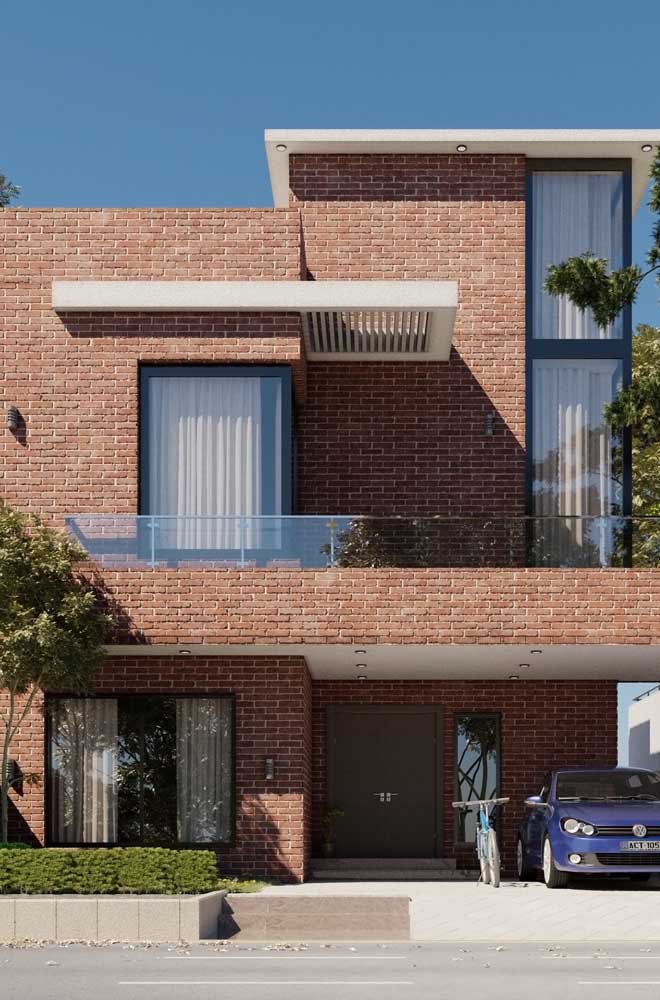 Fachada de uma casa de alvenaria moderna e minimalista com portão de madeira para a garagem interna