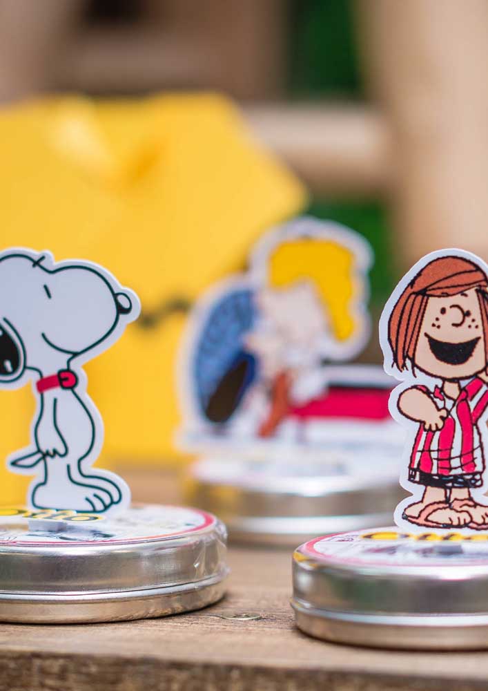 Totens do Snoopy e dos demais personagens da turma decoram as latinhas de doce da festa