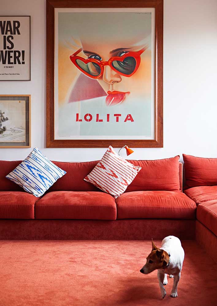 Decoração de sala vermelha com sofá e tapete formando um bloco único de cor