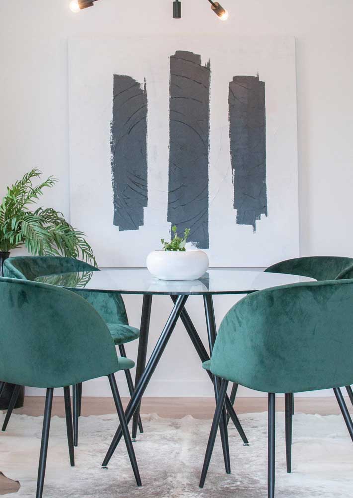 Mesa redonda para sala de jantar complementada pelas modernas cadeiras verdes