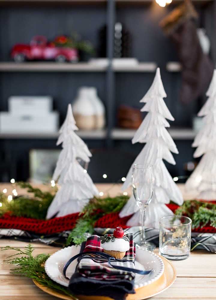 Pratos e guardanapo personalizado com um centro de mesa decorado de Natal.
