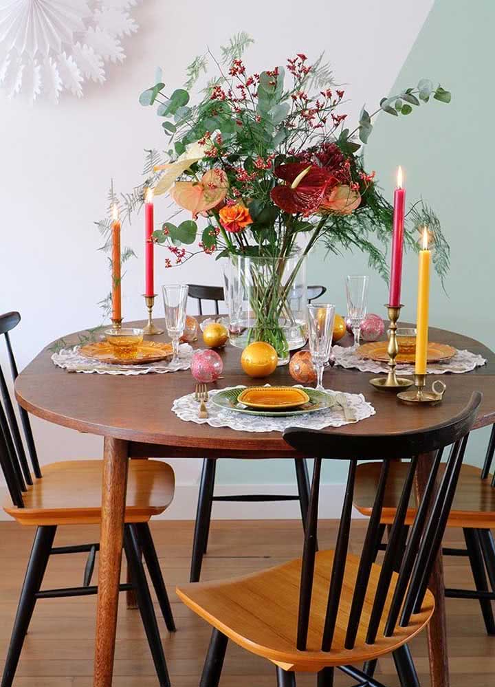 E que tal uma mesa simples para uma ceia mais intimista? Esta proposta usa um vaso elaborado com castiçais de velas.