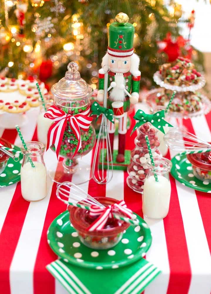 Mesa de Natal vermelha e branca com pratos personalizados e soldadinho.