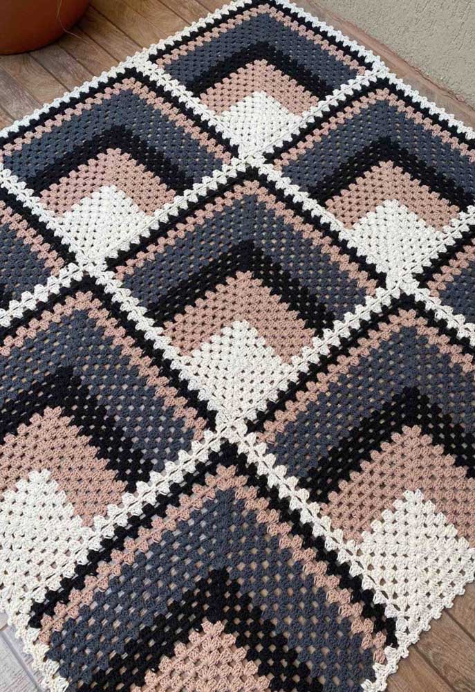 Padronagem interessante com quadrados dentro de uma peça quadrada de tapete de crochê.