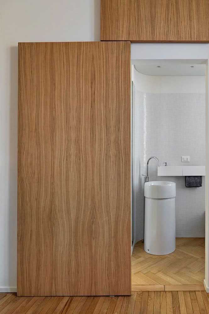 Porta de correr para o banheiro moderno. A madeira dá entrada para um ambiente clean e neutro