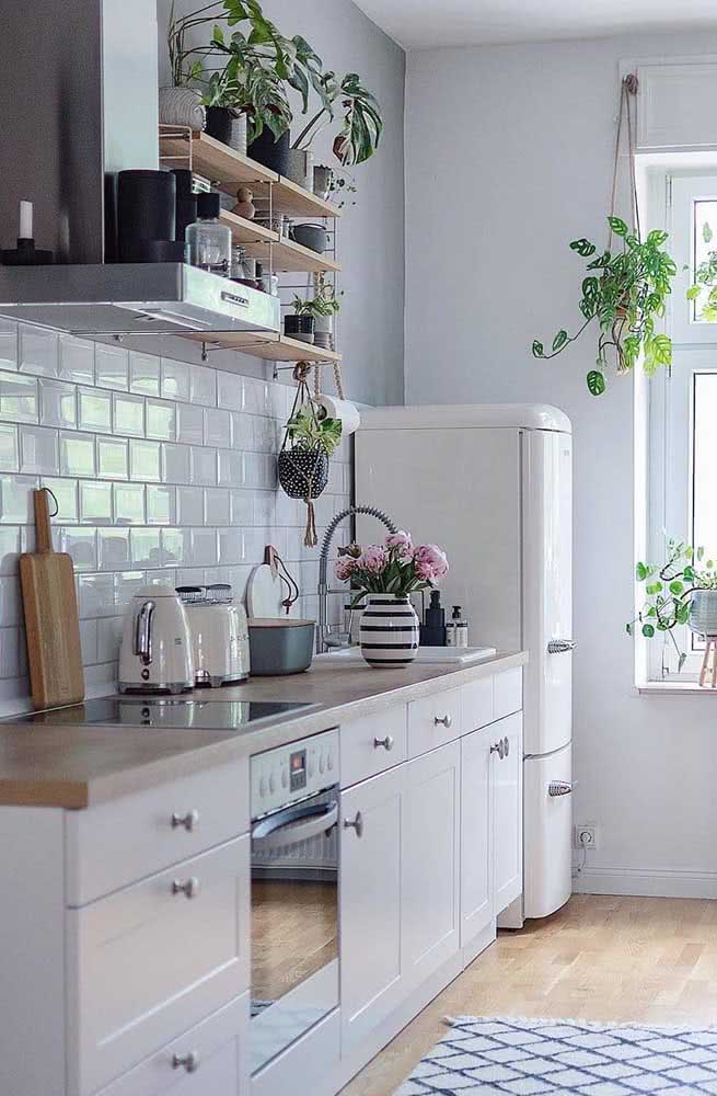 Cozinha simples com geladeira e eletrodomésticos retrô.