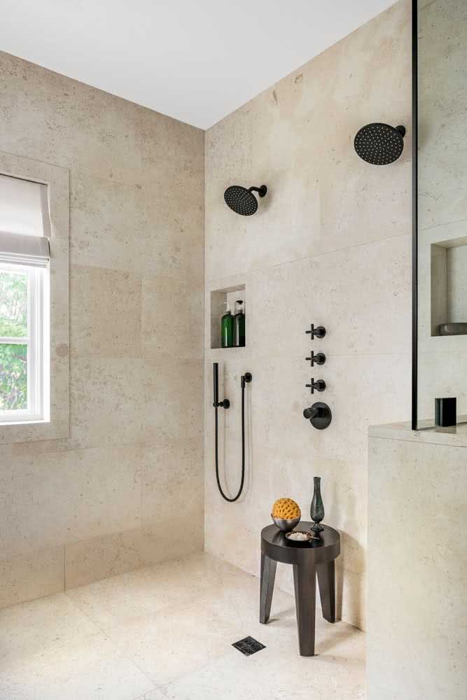 Para criar contraste entre a cor clara do mármore, a escolha das louças e metais na cor preta foi perfeita. Veja neste banheiro que leva o mármore travertino instalado no piso e na parede.