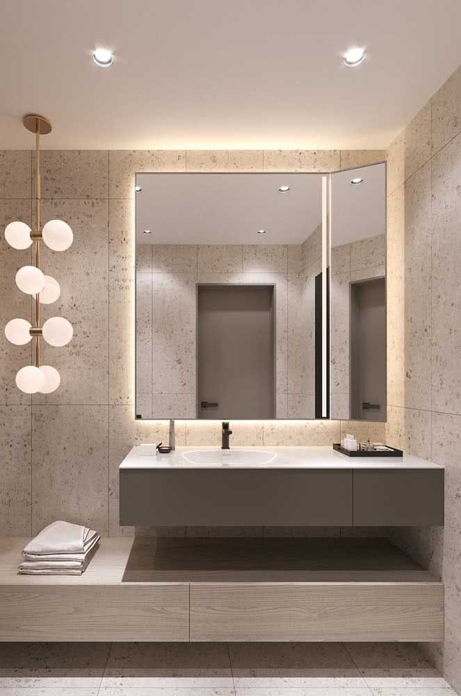 Banheiro charmoso com espelho e iluminação de LED. Piso e paredes revestidas com mármore travertino.