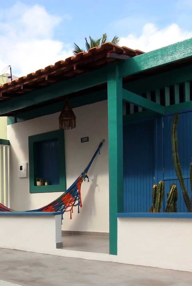 Casa simples com madeira na frente e pintura azul petróleo.