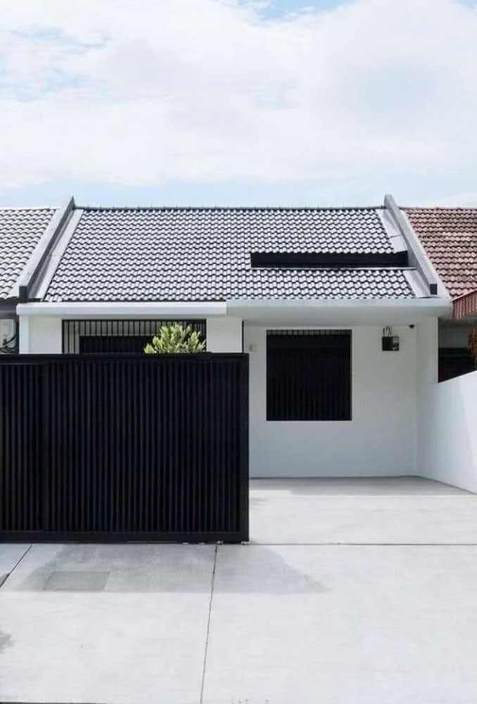 Fachada de casa térrea simples com portão metálico preto.