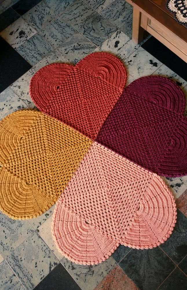 Tapete de crochê multicolor com corações de diferentes cores: vinho, vermelho, mostarda e rosa.