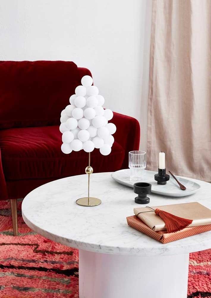 Pinheiro com bolas brancas para decorar a mesa.