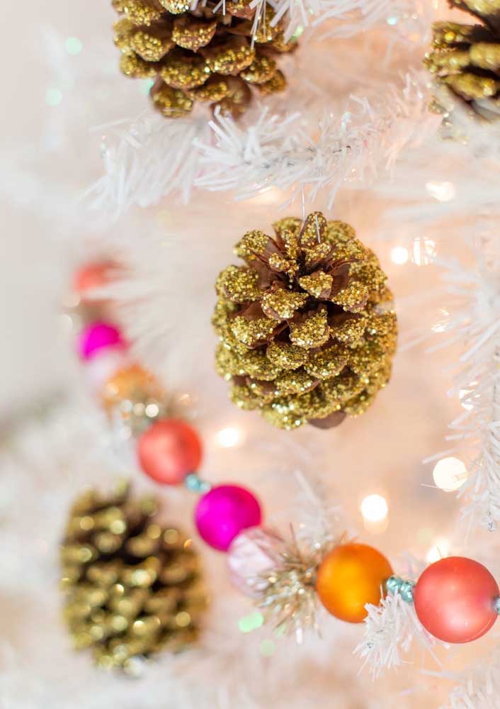 Coloque muito brilho em pinhas natalinas para pendurar na árvore.