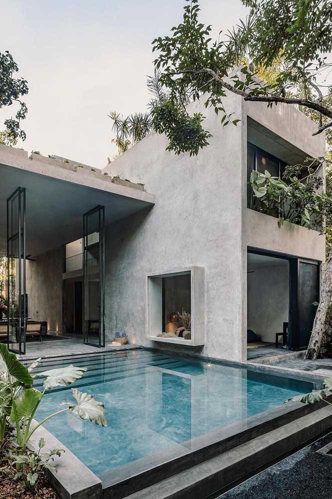 Casa linda de concreto aparente e piscina integrada.
