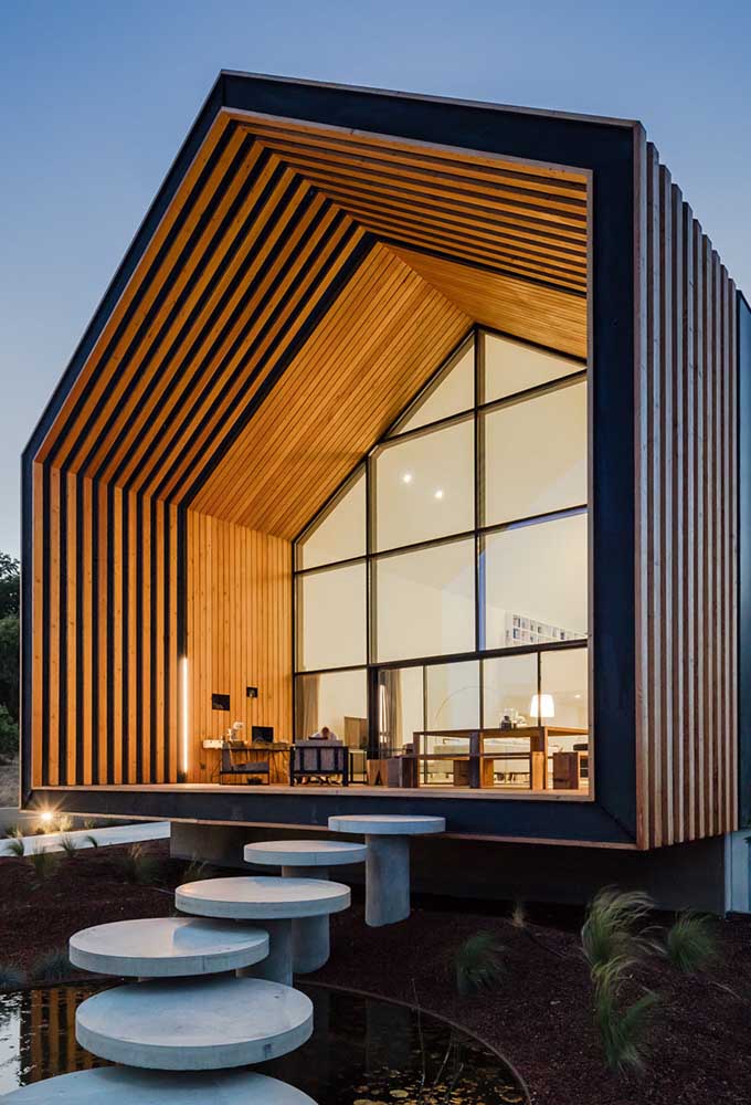 Casa grande de madeira linda com grande iluminação e vidro.
