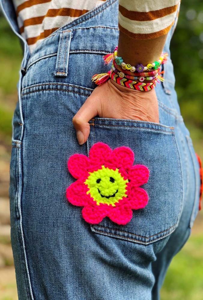 Flor de crochê rosa com centro amarelo Smile para personalizar o modelo de calça jeans.