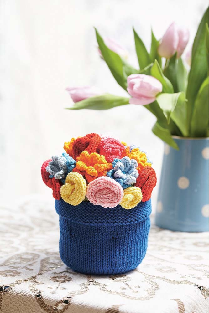 Vaso de crochê com flores coloridas para enfeitar a mesa.