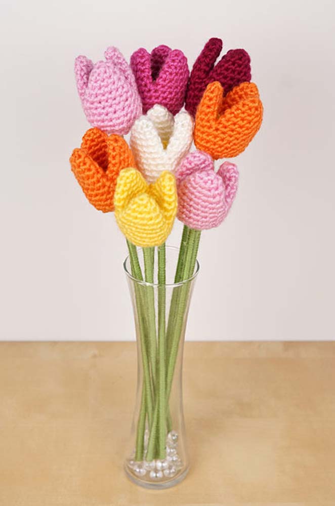 Vaso com belas tulipas de crochê, cada um com um barbante: laranja, vinho, rosa, amarelo e branco.