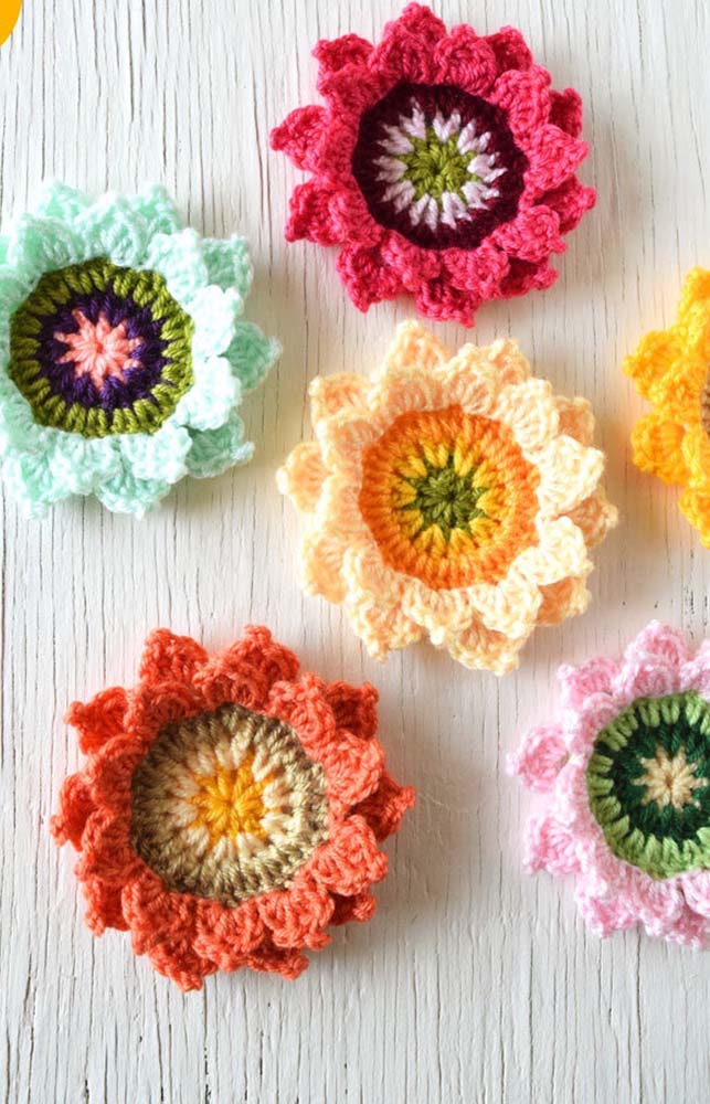 Flores de crochê coloridas: amarelo claro, amarelo, verde, rosa e vermelho.