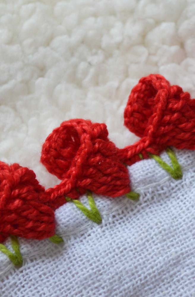 Bico de crochê com detalhes em vermelho e verde para peça branca.