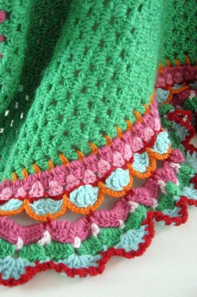 Bico de crochê multicolorido para uma peça com barbante verde.