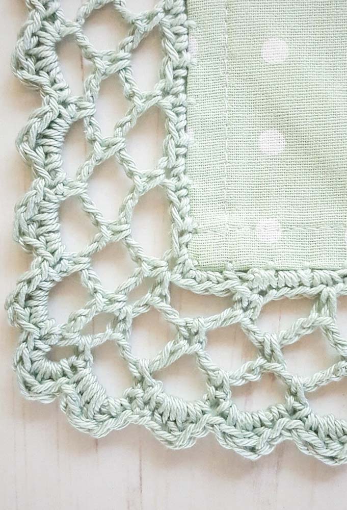 Bico de crochê com verde claro suave para uma peça delicada.